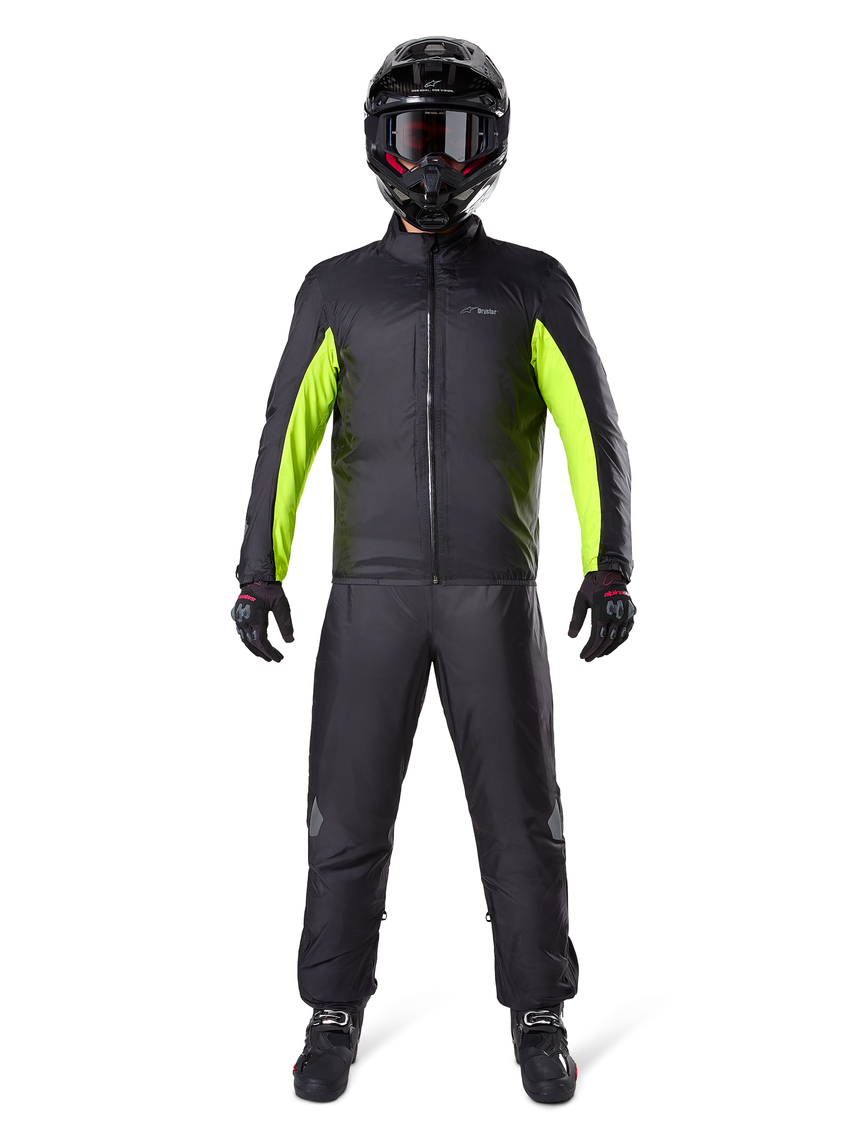 Alpinestars Bogota Pro Drystar 3-seizoenenbroek, zwart, gedragen door een motorrijder in een volledige adventure-outfit inclusief een zwart en neongeel waterdicht jack, zwarte helm en motorlaarzen, ontworpen voor toerprestaties in alle weersomstandigheden.