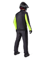 Alpinestars Bogotá Pro Drystar® 3 Seasons broek in het zwart, motorrijder van achteren gezien, zwart jack met fluorescerend gele mouwen, zwarte adventure helm en laarzen, complete adventure touring uitrusting