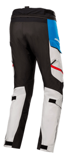 Alpinestars Honda Andes V3 Drystar® broek, textiele motorbroek, Ice Gray met blauwe en felrode accenten, achteraanzicht met zwarte versterkte panelen, verstelbare kuitbanden en verbindingsrits in de taille.