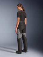 Alpinestars Stella Andes V4 Drystar® broek, motor adventure-touring broek in zwart en donkergrijs, achter- en zijaanzicht op model, voorzien van een duurzame textielconstructie met grijze verstevigingspanelen en een getailleerde pasvorm voor dames.