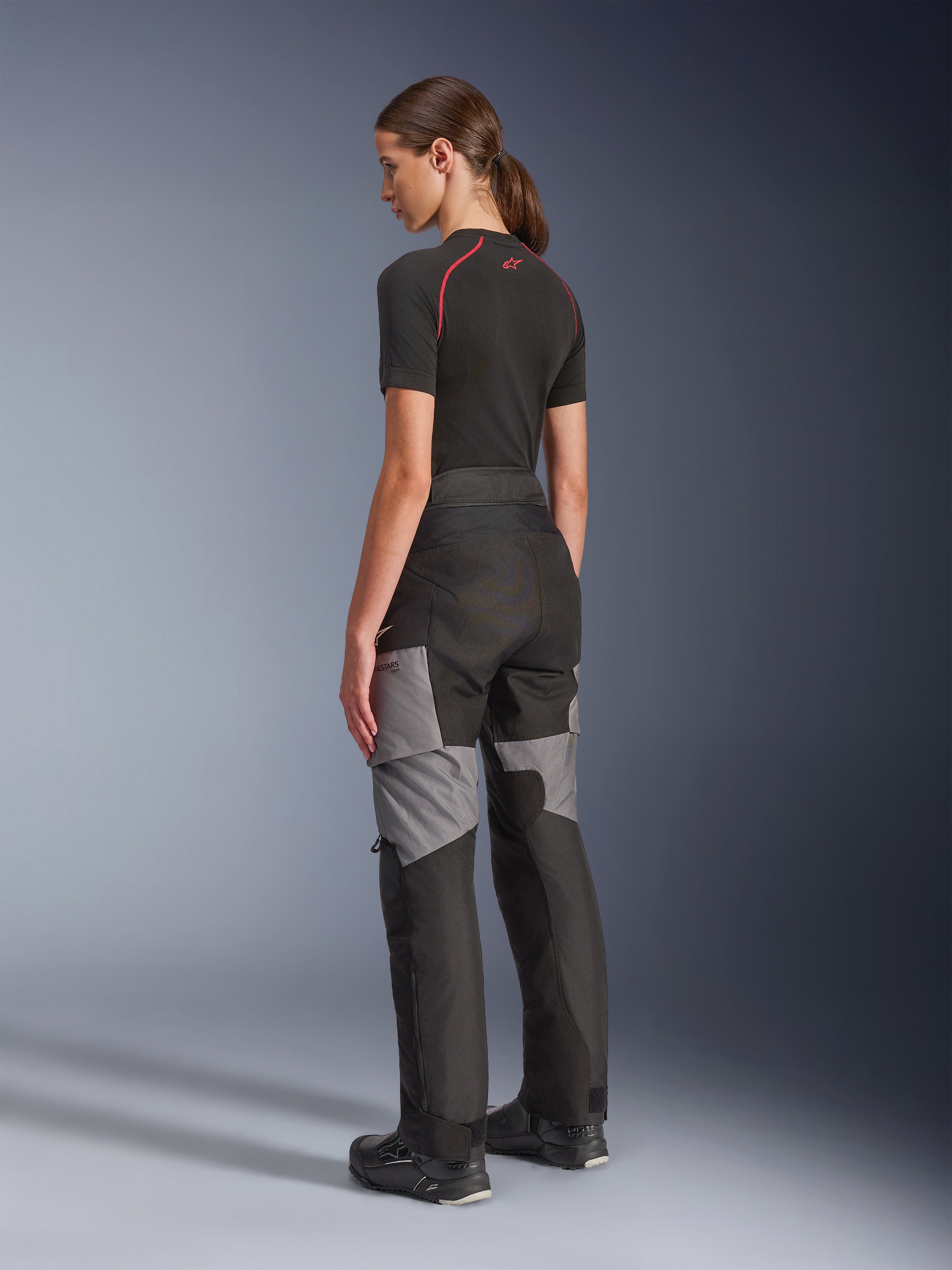 Alpinestars Stella Andes V4 Drystar® broek, motor adventure-touring broek in zwart en donkergrijs, achter- en zijaanzicht op model, voorzien van een duurzame textielconstructie met grijze verstevigingspanelen en een getailleerde pasvorm voor dames.
