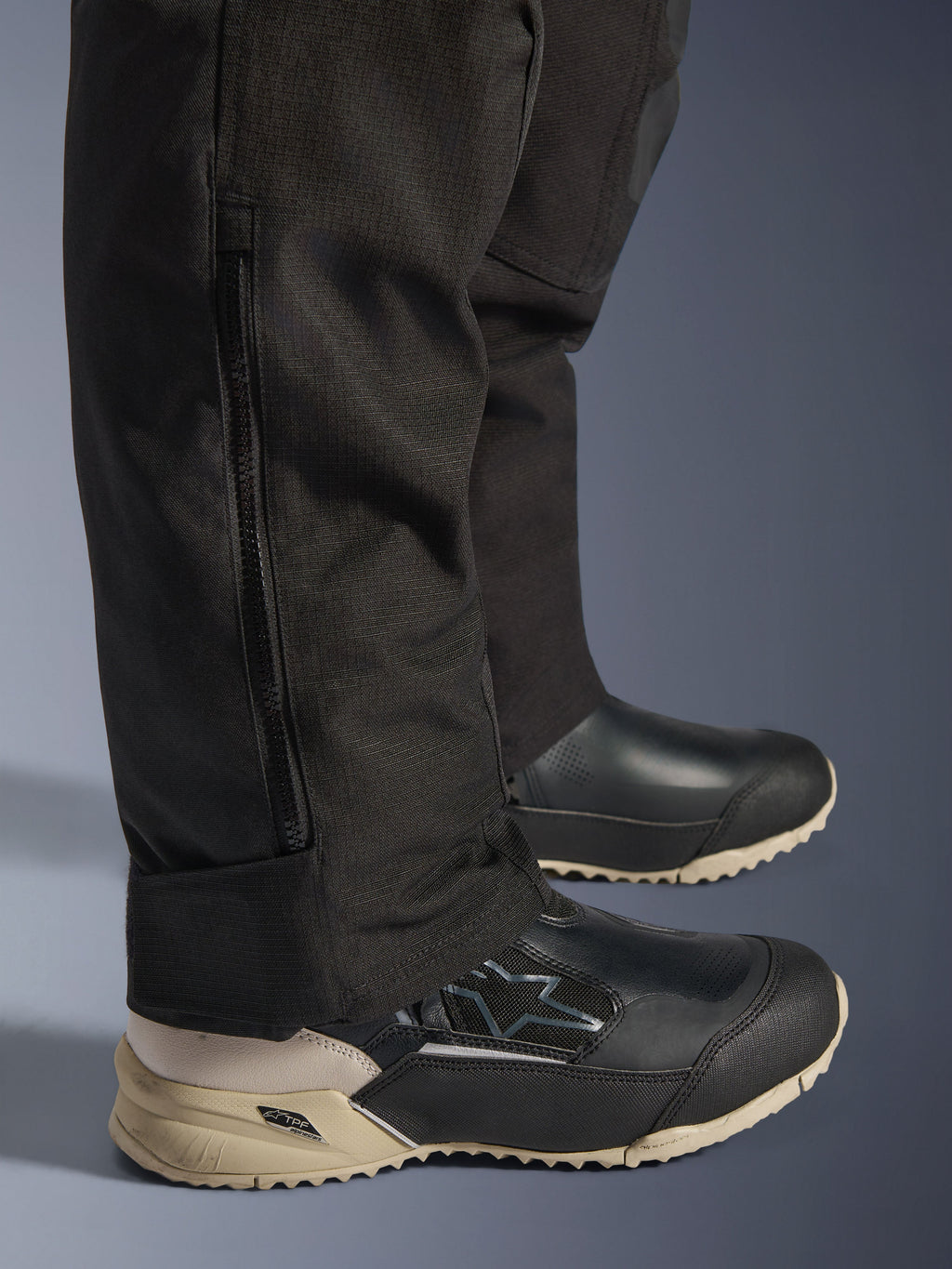 Alpinestars Stella Andes V4 Drystar® broek, detail van het onderbeen in het zwart met verticale zijrits voor de pasvorm over laarzen, duurzame textielconstructie, adventure motoruitrusting voor dames