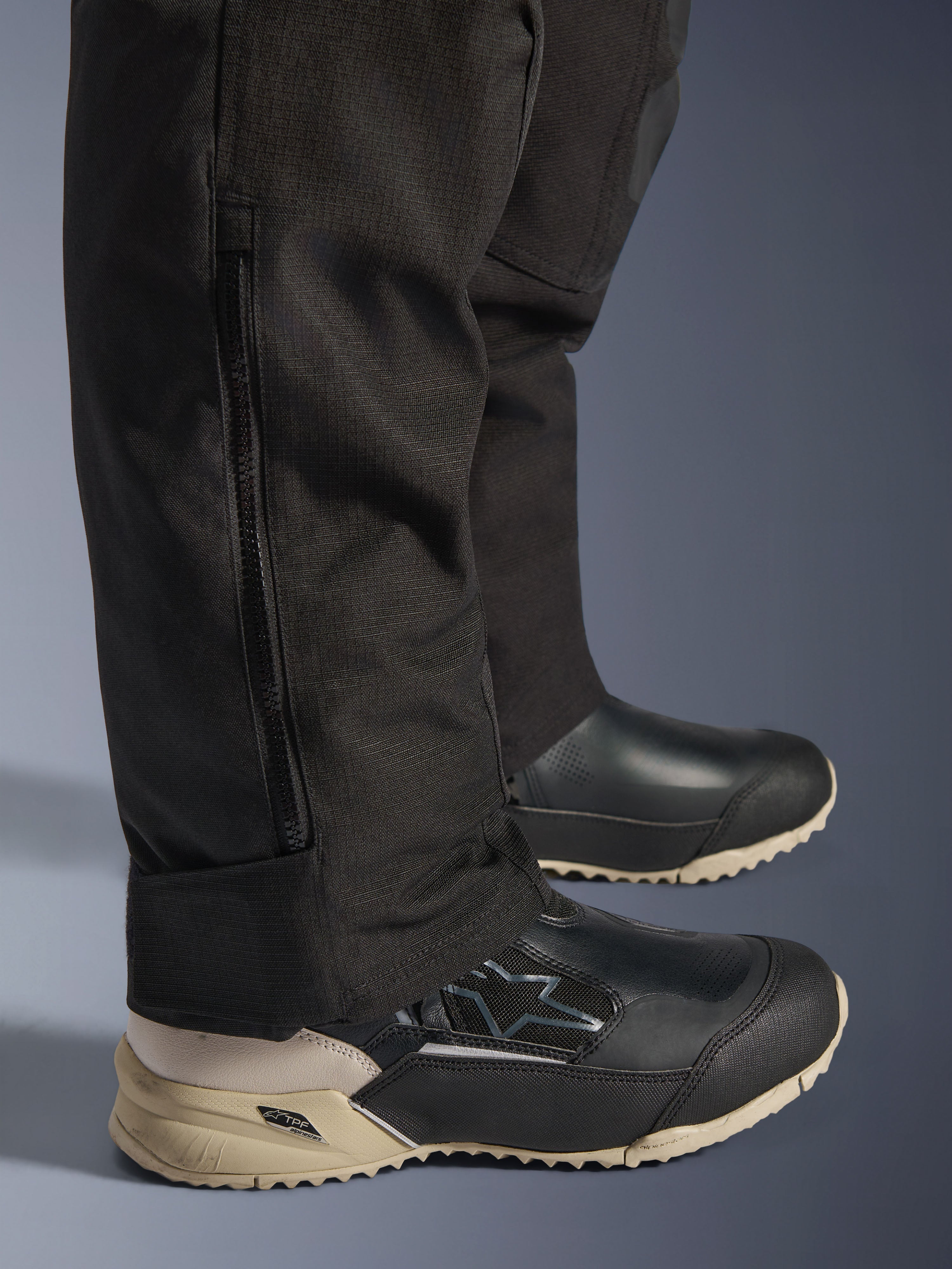 Alpinestars Stella Andes V4 Drystar® broek, detail van het onderbeen in het zwart met verticale zijrits voor de pasvorm over laarzen, duurzame textielconstructie, adventure motoruitrusting voor dames