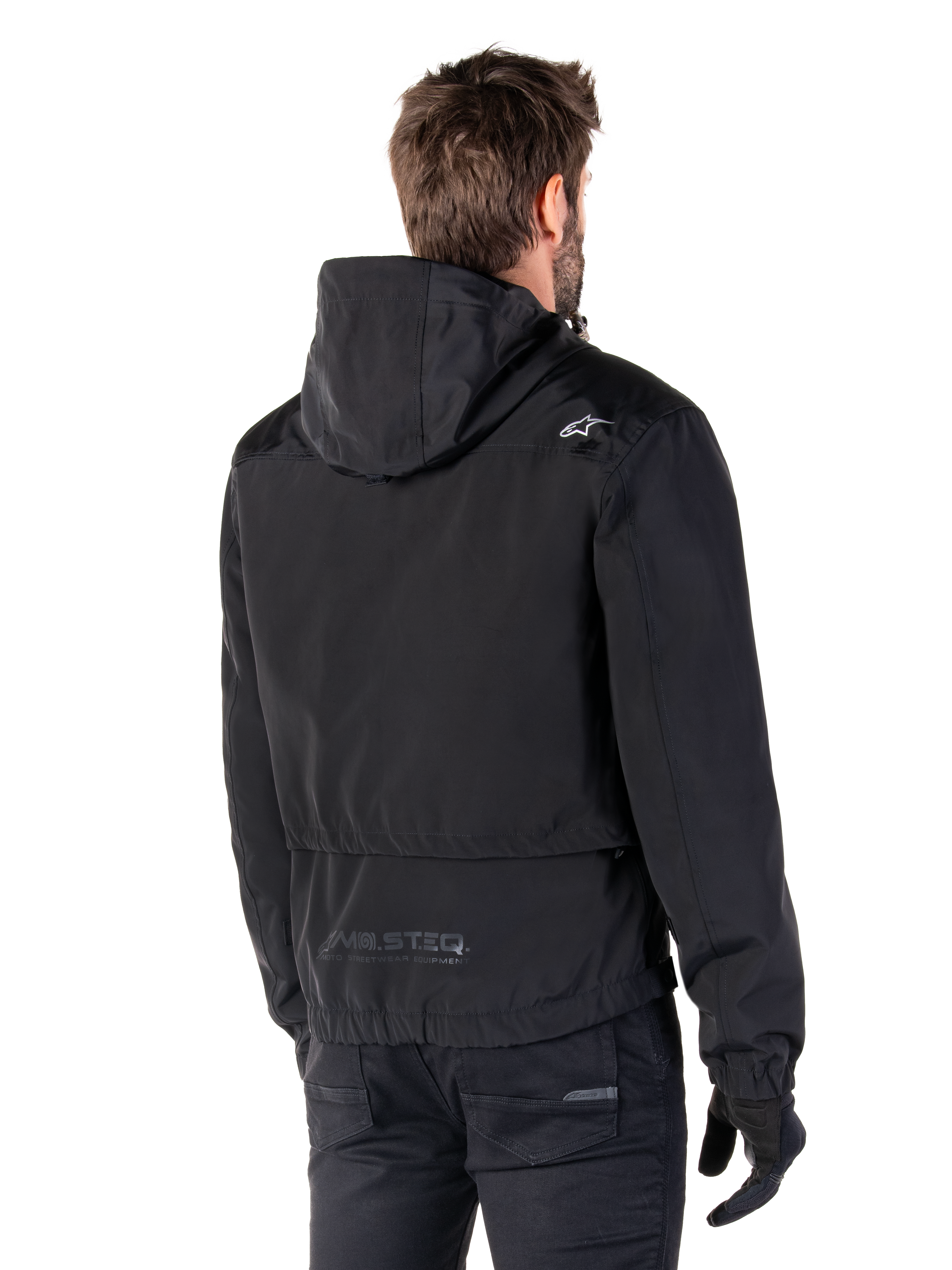 Alpinestars Mootant Waterproof Parka, zwarte motorjas, achteraanzicht met capuchon, wit logo op de schouder en reflecterende MO.ST.EQ.-branding op de onderrug, urban contemporary motorkleding