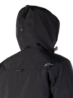 Alpinestars Mootant Waterproof Parka, zwarte motorjas, modulair 4-seizoenen ontwerp met afneembare capuchon, waterdichte gelamineerde constructie, urban contemporary stijl, detail van de achterkant met logo op de schouder