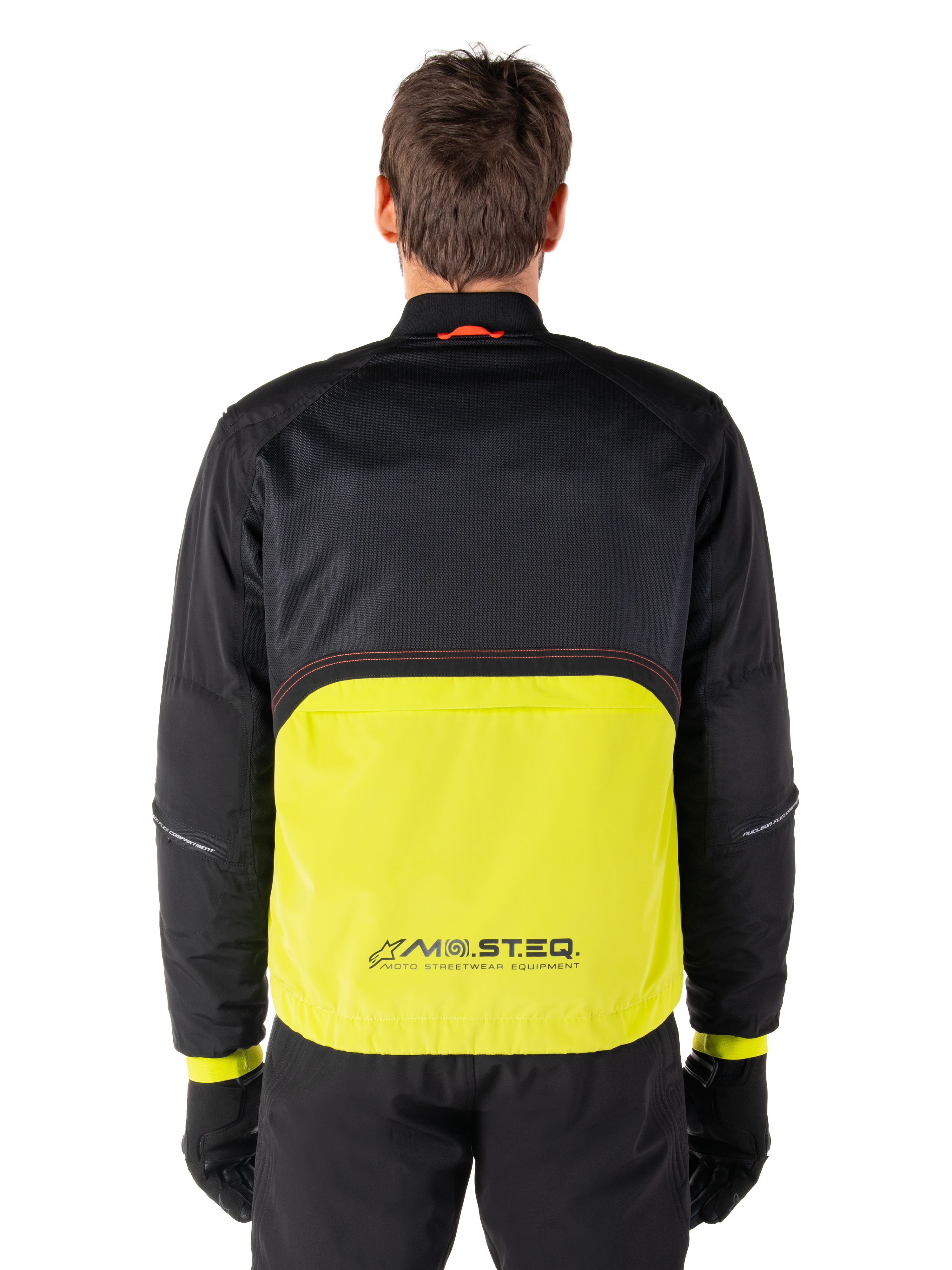 Alpinestars Mootant Waterproof Parka, motorjas, Lime Punch en zwart, achteraanzicht met zwart mesh bovenstuk voor ventilatie en limegroen onderstuk met MO.ST.EQ.-logo, gedragen met zwarte broek en handschoenen