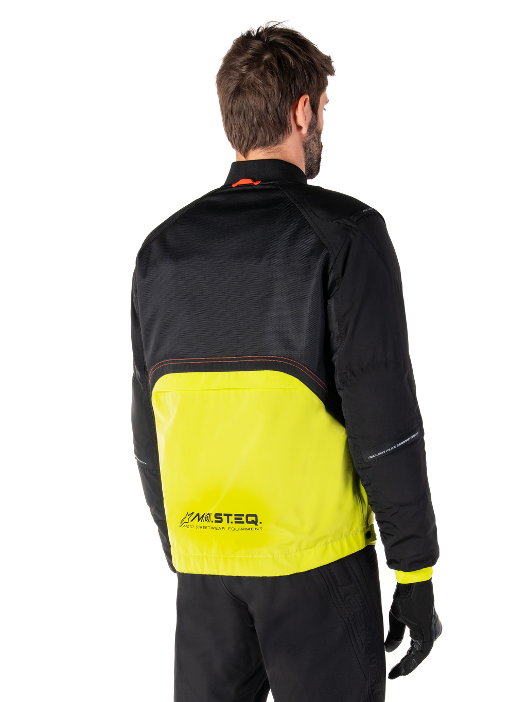 Alpinestars Mootant Waterproof Parka, motorjas, Lime Punch en zwart, achteraanzicht met zwarte mesh bovenzijde en fel limoengroen onderste deel, voorzien van MO.ST.EQ.-branding, gedragen met zwarte motorbroek en handschoenen