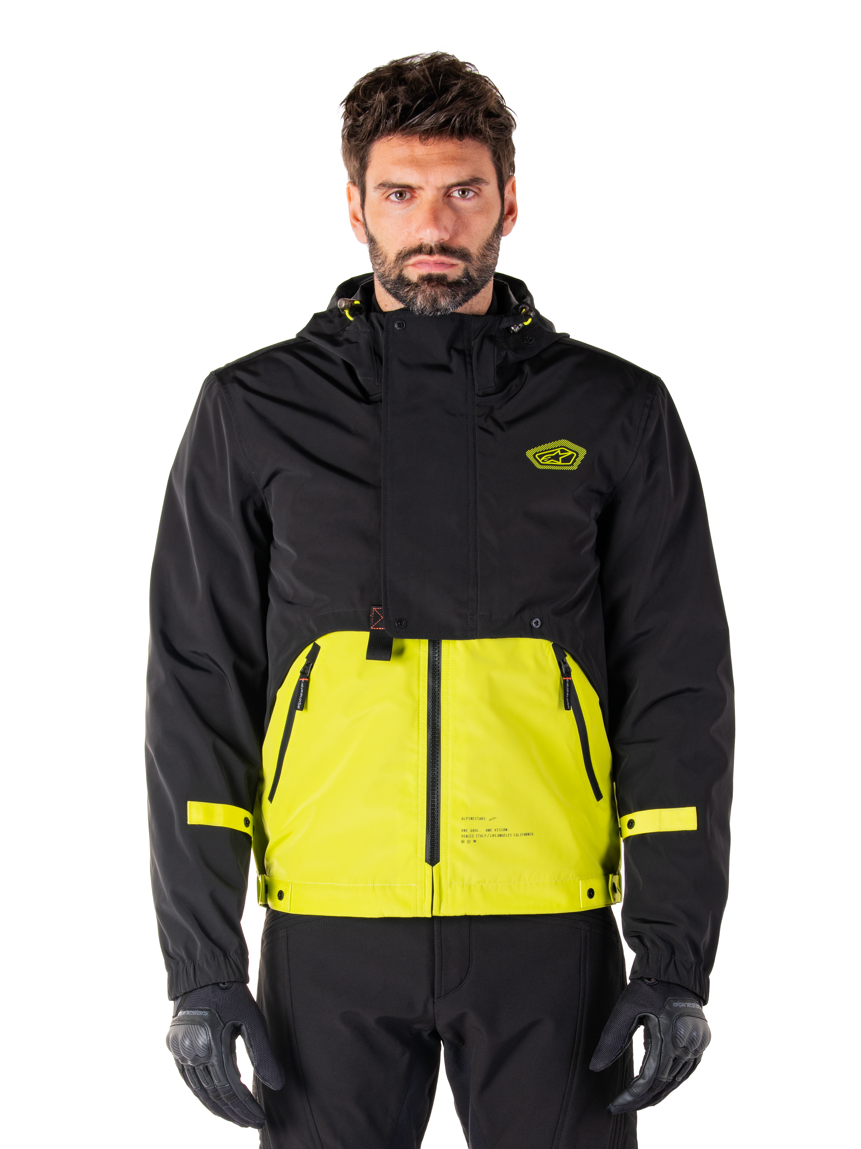 Alpinestars Mootant Waterproof Parka, motorjas voor touring, Lime Punch en zwart, tweekleurig ontwerp met capuchon, felgele onderkant en zwart bovenstuk, gele mouwbandjes, logo op de borst, technische modulaire stijl