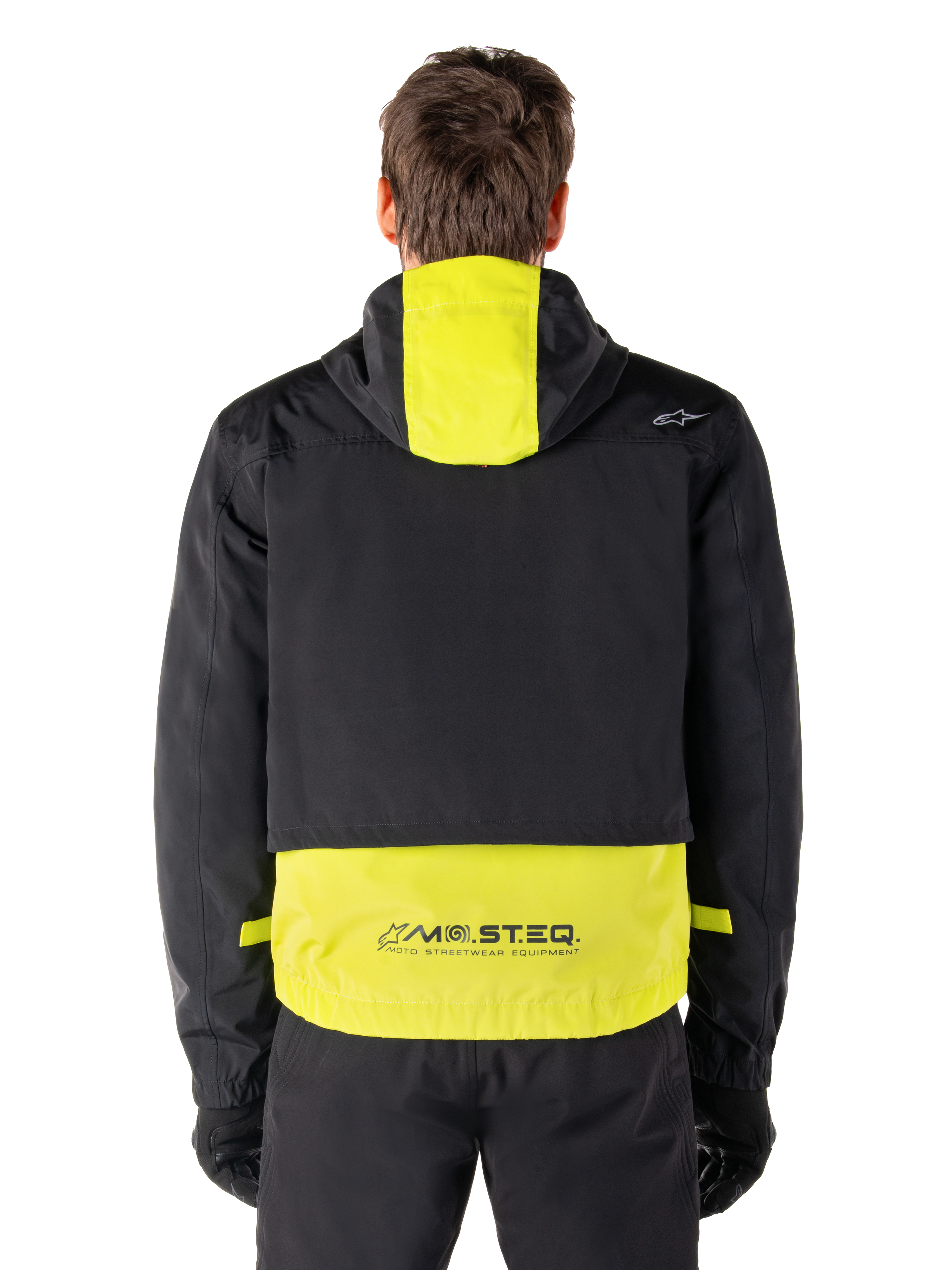 Alpinestars Mootant Waterproof Parka, motorjas, Lime Punch en zwart, achteraanzicht met capuchon en reflecterende MO.ST.EQ.-branding op de onderrug, gedragen met zwarte motorbroek en handschoenen.