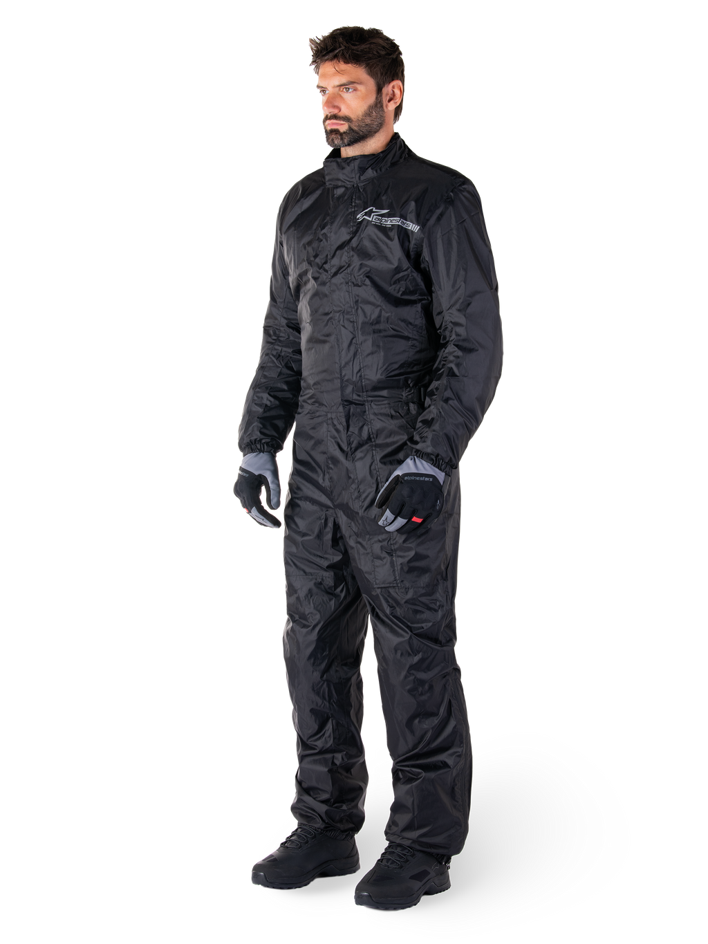 Alpinestars Hurricane Rain V2 Suit, zwart, eendelig waterdicht motorregenpak, gedragen met handschoenen en laarzen, voorzien van reflecterende Alpinestars branding op de borst, lichtgewicht ontwerp voor bescherming tegen nat weer