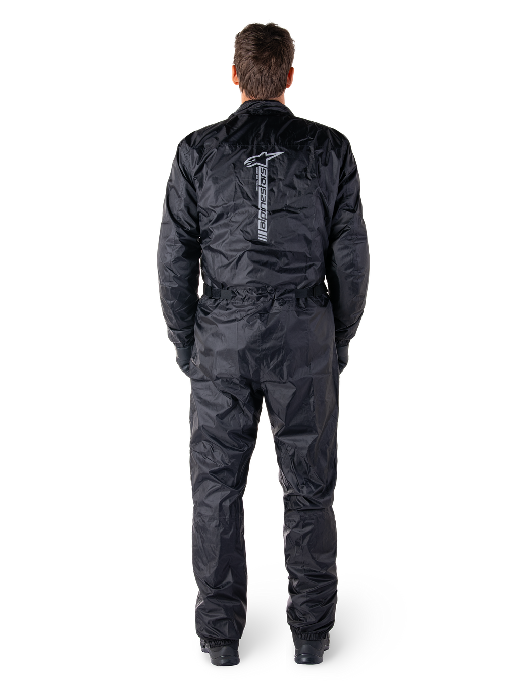 Alpinestars Hurricane Rain V2 Suit, zwart eendelig waterdicht motorpak, achteraanzicht met groot verticaal Alpinestars-woordmerk en logo, lichtgewicht gekreukelde stof met elastische taille en manchetten, ontworpen voor bescherming tijdens het rijden in nat weer
