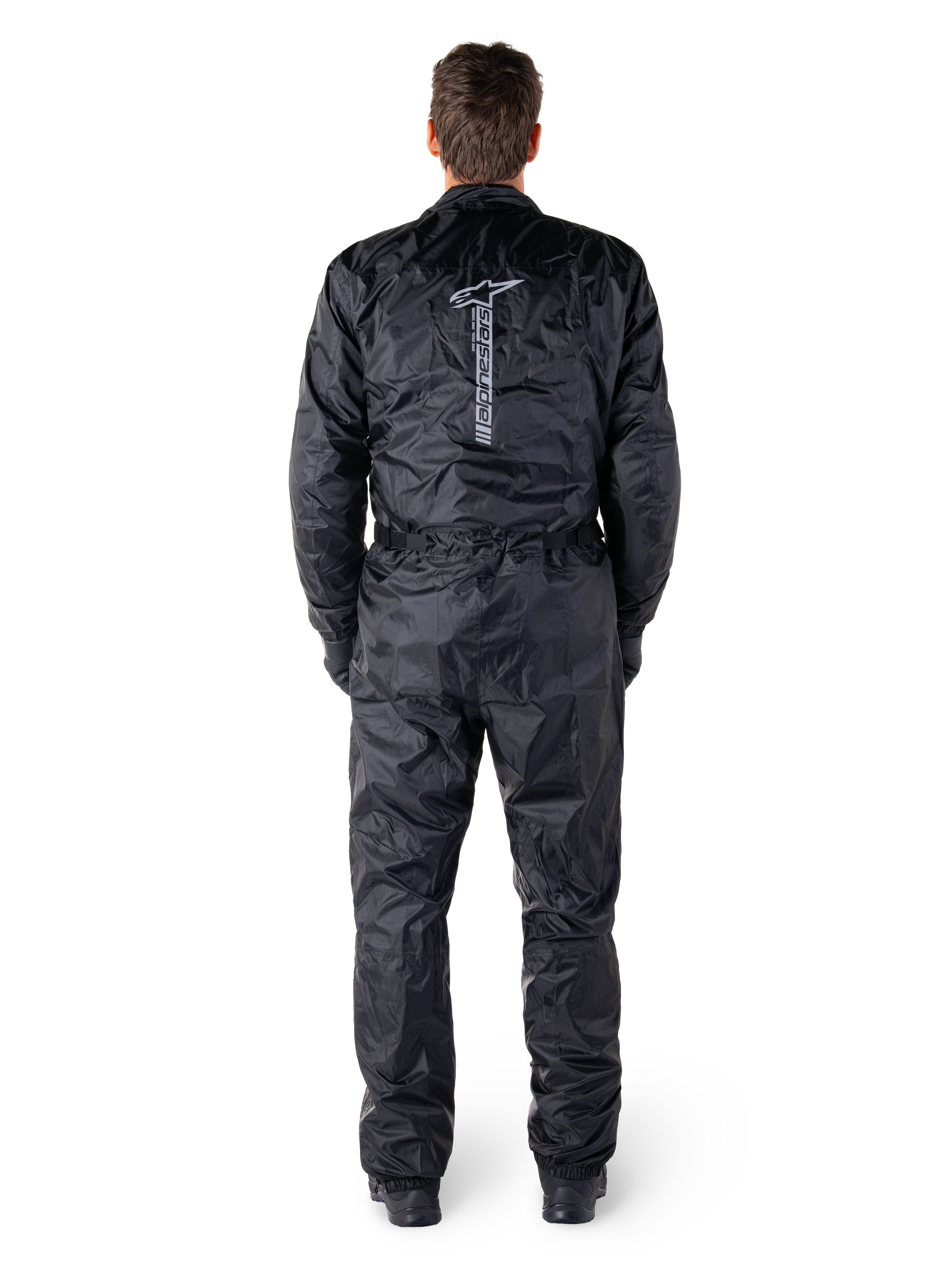 Alpinestars Hurricane Rain V2 Suit, zwart eendelig waterdicht motorpak, achteraanzicht met groot verticaal Alpinestars-woordmerk en logo, lichtgewicht gekreukelde stof met elastische taille en manchetten, ontworpen voor bescherming tijdens het rijden in nat weer