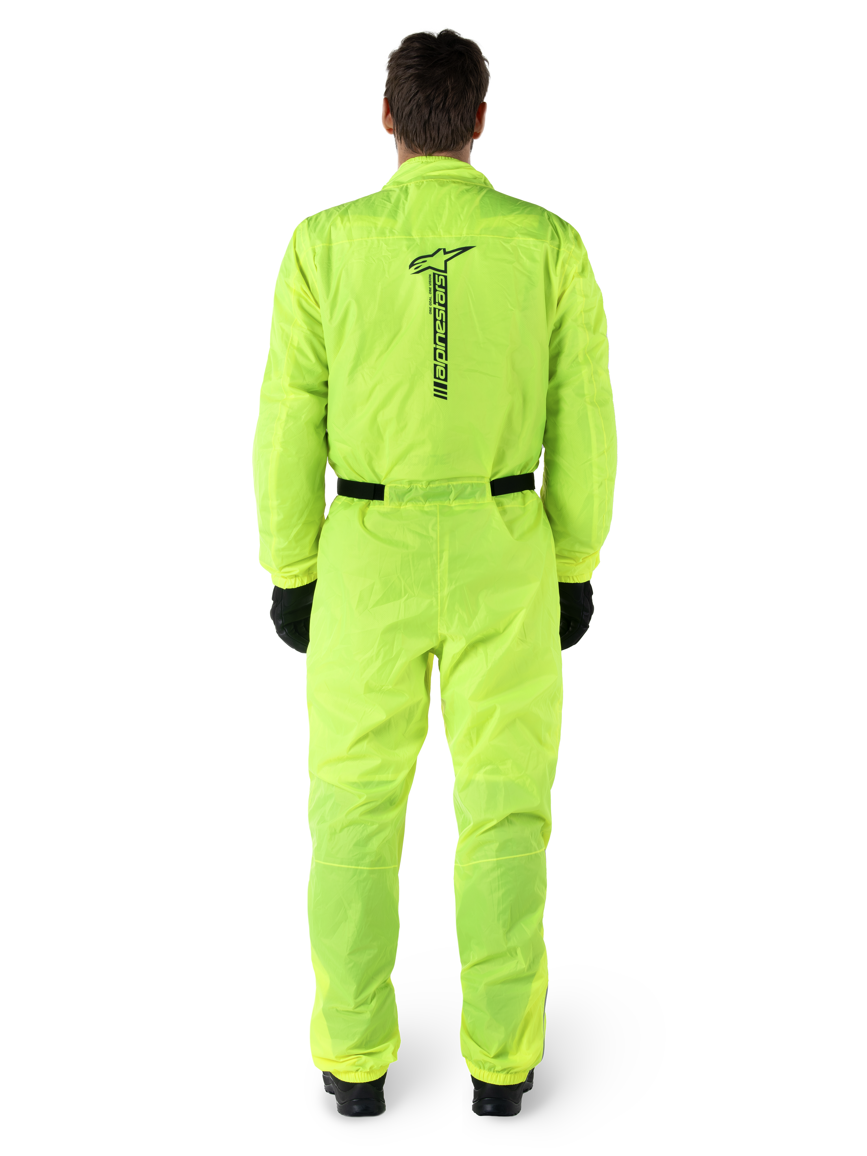 Alpinestars Hurricane Rain V2 Pak, eendelig motorregenpak, fluoriserend geel, achteraanzicht met verticale zwarte Alpinestars-branding, elastische taille en manchetten, gedragen met zwarte handschoenen en laarzen, waterdichte en windbestendige motorkleding