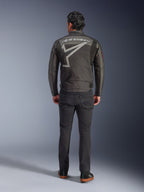 Alpinestars Axton Jacket, motorjas, Black Anthracite Red Tangerine, achteraanzicht met groot grijs Alpinestars-logo en stergrafiek, accordeonpanelen op de schouders, gedragen met zwarte broek en casual zwarte schoenen