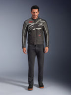 Alpinestars Axton jas, motorjas, Black Anthracite Red Tangerine, gedragen door een model met een donkere broek, voorzien van een rondom lopend grijs Alpinestars-logo, rode merkpatches en een waterbestendige textiele buitenlaag voor stadsritten