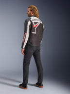 Alpinestars Axton Jas, motorjas, zwart, gebroken wit en felrood, achteraanzicht gedragen door mannelijk model, voorzien van groot Alpinestars-sterlogo en woordmerk op de rug, vintage racing-geïnspireerd ontwerp met accordeonpanelen, gecombineerd met zwarte broek en sneakers