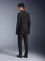 Alpinestars Aeroshell Airflow Jacket, zwart, lichtgewicht textiele motorjas, gedragen door model met bijpassende zwarte uitrusting, achteraanzicht met de nadruk op lasergeperforeerde ventilatiepanelen en sportieve pasvorm met verlengde achterkant.