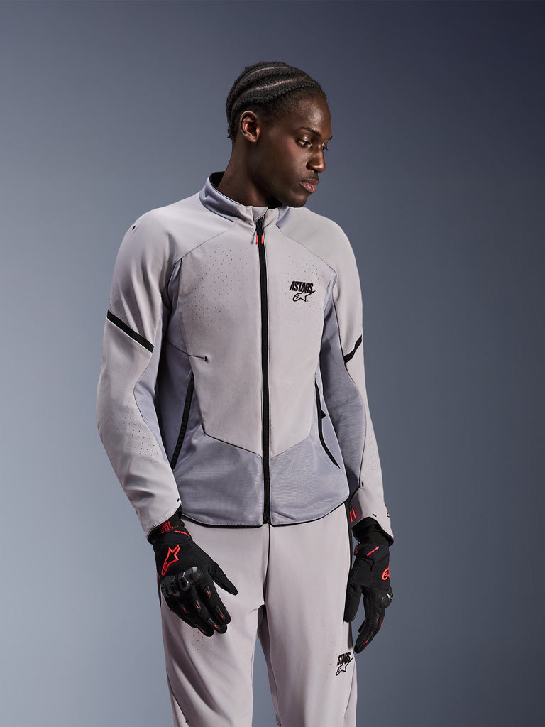 Alpinestars Aeroshell Airflow Jacket, lichtgrijze motorjas met zwarte details, geperforeerd ademend ontwerp, unisex, getoond met bijpassende broek en zwarte handschoenen met rode accenten