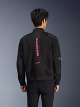 Achteraanzicht van een motorrijder die de Alpinestars Flight Air Jacket draagt in Black Bright Red, urban motorjas in bomberstijl met 3D-mesh-constructie, voorzien van groot verticaal rood Alpinestars-logo en sterlogo op de rug, technische motorkleding geïnspireerd op streetwear