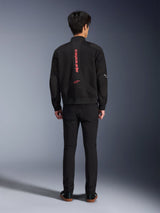 Alpinestars Flight Air Jacket in Black Bright Red, achteraanzicht van een stedelijke motorjas in bomberstijl, voorzien van verticale rode Alpinestars-branding en logo op de rug, lichtgewicht 3D mesh-constructie, gedragen met een zwarte broek voor een eigentijdse look.
