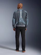 Alpinestars Flight Air Jacket in Storm Gray, back view of male model wearing urban-style motorcycle jacket with 3D mesh panels and vertical Alpinestars branding, paired with black pants for a modern commuter look