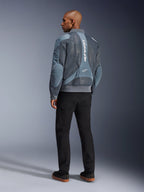 Alpinestars Flight Air Jacket, Storm Gray motorjas, achteraanzicht, voorzien van 3D mesh ventilatiepanelen en verticale witte Alpinestars-branding, gedragen met zwarte broek en zwarte sneakers, urban commuter-stijl