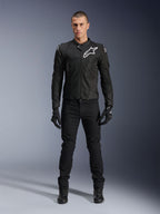 Alpinestars Viper Air V4 Jas, zwarte textiele motorjas, wit logo op de borst en schouders, gedragen met zwarte motorbroek en handschoenen, voorzien van tech mesh panelen voor luchtstroom, volledige studio-opname