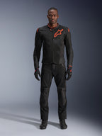 Alpinestars Viper Air V4 Jas in Black Red Fluo, motorjas gedragen door een model met bijpassende zwarte broek en handschoenen, voorzien van mesh-panelen voor luchtstroom en een opvallend rood Alpinestars-logo op de borst, sportieve motoruitrusting