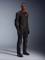 Model draagt Alpinestars Viper Air V4-jas in Black Red Fluo, voorzien van mesh panelen en rode sterlogo's op de borst en schouder, gecombineerd met bijpassende zwarte motorbroek, handschoenen en motorschoenen, professionele motorrijuitrusting voor op de weg