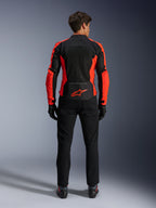 Alpinestars Viper Air V4 Jas, fluorrood en zwart, achteraanzicht met grote tech mesh-panelen en felrode fluorescerende accenten aan de zijkanten, rood Alpinestars-logo op de onderrug, gedragen met zwarte motorbroek en handschoenen