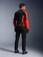 Alpinestars Viper Air V4 Jas, Red Fluo Black, achteraanzicht op model, voorzien van technische mesh-panelen en een rood sterlogo op de onderrug, gecombineerd met een zwarte motorbroek en handschoenen voor een complete motorlook.