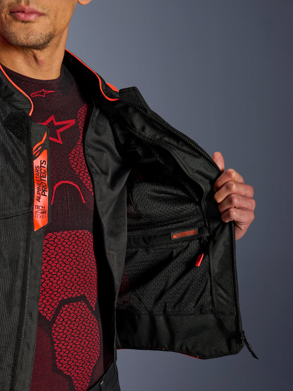 Alpinestars Viper Air V4 Jas interieurdetail, met het waterdichte binnenvak en de ademende tech mesh-voering, fluorescerend rode en zwarte accenten en Tech-Air Ready-branding