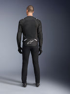 Alpinestars T-Sps Air V2 Jas, achteraanzicht, zwart-witte textiele motorjas, voorzien van een groot mesh rugpaneel voor maximale luchtstroom en wit Astars-logo op de onderrug, gedragen met een zwarte motorbroek en handschoenen