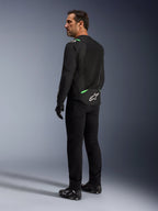 Alpinestars T-SPS Air V2 Jas in Black Fluo Green, man getoond vanuit rug- en zijprofiel, gecombineerd met zwarte motorbroek en motorschoenen, voorzien van geventileerde tech mesh panelen, felgroene accenten op de schouders en onderrug, wit sterlogo op de achterzijde.