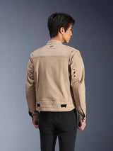 Alpinestars Bruiser Jacket, Brown urban motorcycle jacket, rear view showing articulated pleated shoulders and adjustable waist straps, worn with black pants, contemporary workwear-inspired riding gear