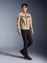 Alpinestars Bruiser Jacket, Urban Motorcycle Jacket, Tan, worn by a male model with black slim-fit pants and black sneakers, workwear-inspired textile construction with black zipper accents, contemporary urban street style.