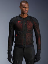 Alpinestars Troop-Air Pro Jacket, technical armored mesh motorcycle jacket in Black and Red Fluo, worn by a model, featuring large mesh ventilation panels, red underlay, and red zipper pulls, urban riding style.