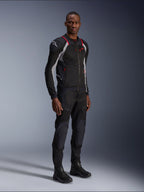 Alpinestars Troop-Air Pro Jacket, Black Ash Gray en Bright Red, technisch gepantserde mesh motorjas, voorzien van rode accenten en een wit logo op de schouder, gedragen met bijpassende zwarte broek en laarzen, moderne urban motorkleding