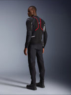 Alpinestars Troop-Air Pro Jas, motorjas, zwart, asgrijs en felrood, achteraanzicht op model, met rode accentlijnen en mesh ventilatiepanelen, gedragen met zwarte broek en laarzen, urbane motorstijl