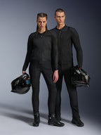 Mannelijke en vrouwelijke modellen die zwarte Alpinestars Troop-Air Pro Jackets dragen, technische mesh motoruitrusting gecombineerd met een bijpassende zwarte broek en laarzen, elk met een zwarte helm, tonen gecoördineerde urban motorkleding.