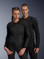 Alpinestars Troop-Air Pro Jas, zwarte technische gepantserde luchtjassen gedragen door een mannelijk en vrouwelijk model, voorzien van ademende mesh-panelen en geïntegreerde bescherming, urbane motorkleding ontworpen voor rijden in warm weer