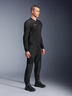 Alpinestars Troop-Air Pro Jas, technische gepantserde doorwaaijas, zwart, gedragen door een model met bijpassende zwarte motorbroek en laarzen, voorzien van een geavanceerde 2D tech mesh-structuur en ademende ventilatiepanelen, urban contemporary motorkleding.
