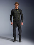 Mannelijk model draagt Alpinestars Troop-Air Jacket in Black Yellow Fluo, voorzien van technische mesh-panelen en felgele accenten, gecombineerd met een zwarte motorbroek en schoenen, eigentijdse motorkleding voor warm weer