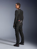 Alpinestars Stella T-Sps Air v2 damesmotorjas, zwart en Diva Pink, textiele motorjas getoond vanuit een schuin achteraanzicht, voorzien van grote mesh-panelen voor ventilatie en een wit sterlogo op de rug, gedragen met bijpassende zwarte motorbroek, handschoenen en laarzen