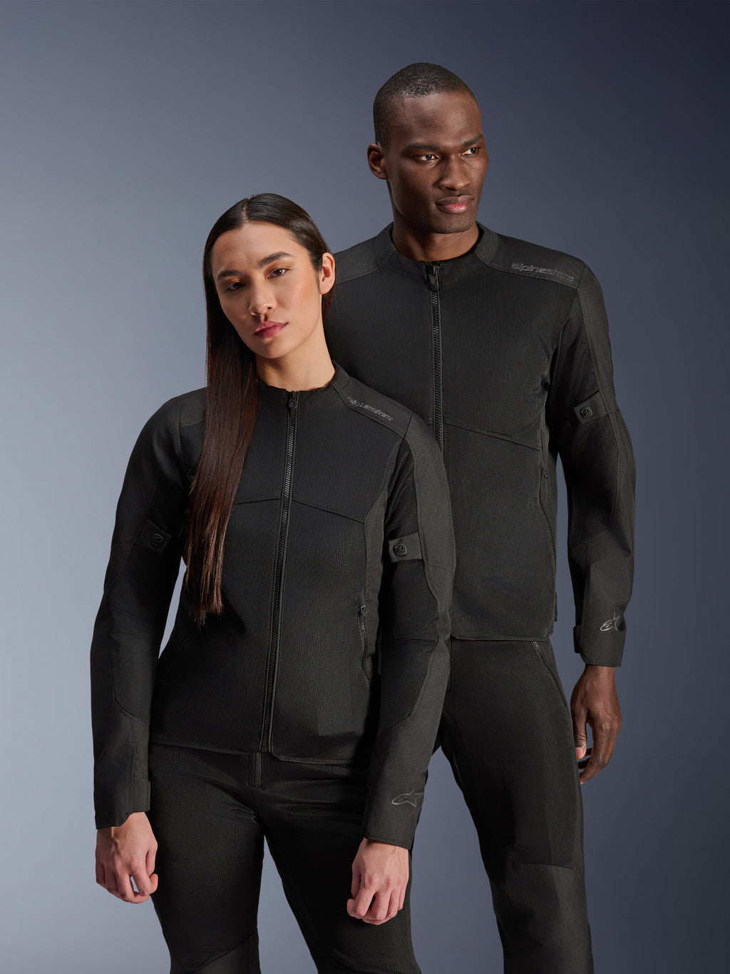 Alpinestars Stella C-1 Air Jacket, zwart, gedragen door een mannelijk en vrouwelijk model, technische mesh-constructie voor optimale luchtstroom, reflecterende logo's, strakke urban motoruitrusting