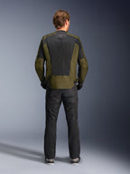 Achteraanzicht van een motorrijder die het Alpinestars C-1 Air Jacket in Khaki en Zwart draagt, voorzien van een groot tech mesh rugpaneel voor ventilatie, gecombineerd met een zwarte motorbroek, urban eigentijdse motorkleding.