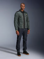 Alpinestars Ignite Air Jacket, Urban Gray Black Blue, urban motorjas, gedragen door een model met donkere denim jeans en zwarte sneakers, voorzien van een mesh body, traditionele overhemdkraag, Harrington-geïnspireerd silhouet en gouden Alpinestars branding.