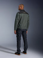 Alpinestars Ignite Air Jas in Urban Gray Black Blue, achteraanzicht op model, met een mesh body, een zwart schouderstuk met witte tekst en gestreepte manchetten, gecombineerd met een donkere denim jeans en zwarte sneakers, urban lifestyle motorkleding
