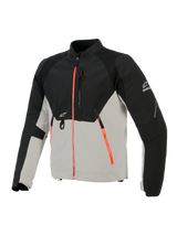 Alpinestars Provoke Jacket, stedelijk motorjack, zwart en metaalgrijs met fluorescerend rode ritsaccenten, voorzien van lasergeperforeerde borstpanelen, ripstop softshell-versterkingen en D-ring bevestiging aan de voorzijde, straatklaar ontwerp voor rijden bij warm weer