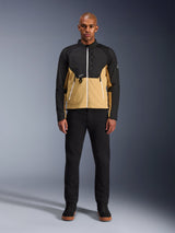 Alpinestars Provoke Jacket in Black Camel, urban motorjas met een tweekleurig zwart en camel ontwerp, gedragen door een model met zwarte broek en zwarte schoenen, eigentijds silhouet met witte ritsen en technische softshell-constructie.